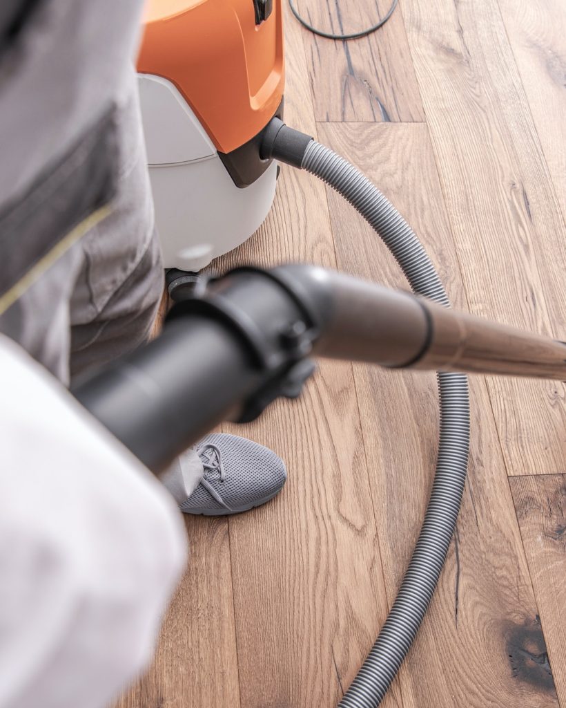 male-worker-vacuuming-hardwood-flooring-.jpg